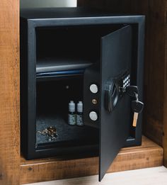 an open safe box on top of a wooden shelf