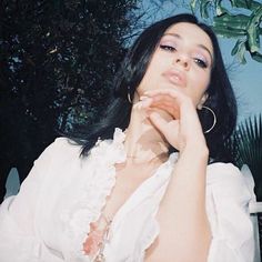 a woman sitting on a bench with her hand under her chin