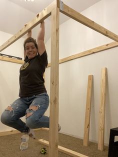 a woman standing on top of a wooden structure in the middle of an unfinished room