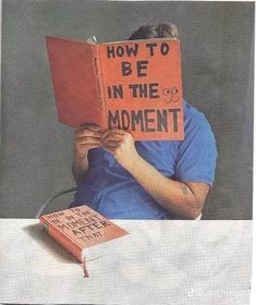 a person sitting at a table with an orange book in front of their face, reading how to be in the moment