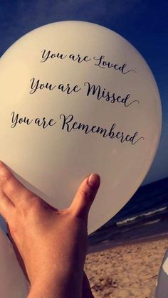 someone holding up a white frisbee that says, you are loved you are missed you are remembrance