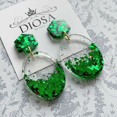 green glitter earrings on top of a white broccoli paper with the word diosa written in it