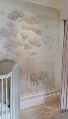 a baby crib in front of a wall with elephants on it