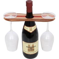 two wine glasses and a bottle on a wooden rack with three empty wine glasses in it