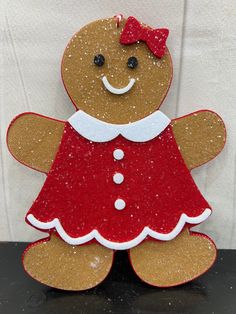 a ginger with a red dress is standing on a table