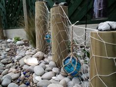 there are some rocks in front of the fence that is made out of wood and wire