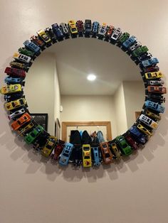 a mirror that has cars on it in the shape of a circle, hanging on a wall