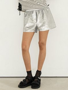 This product, a pair of silver sequins brief shorts, merges glamour with a playful design. It features an all-over sequin embellishment that adds sparkle and a fun vibe to any outfit. These shorts are perfect for making a statement, whether worn casually or dressed up for a night out. - These silver sequins brief shorts are crafted from high-quality fabric, ensuring both comfort and durability.- The shorts feature all-over sequin embellishment, providing a dazzling and eye-catching element.- A handmade Cali medal decoration has been attached to the lower right side of the front panel to add a unique point of interest.- The elastic waistband offers a comfortable fit, making these shorts easy to wear for various occasions, from casual outings to festive events. Chic Sequined Bottoms For Summer, Metallic Disco Shorts For Summer, Silver Disco Bottoms For Summer, Shiny Shorts For Night Out In Summer, Shiny Shorts For Summer Night Out, Glamorous Metallic Silver Bottoms For Night Out, Shiny Shorts For Party, Shiny Short Bottoms For Party, Shimmer Bottoms For Summer Night Out