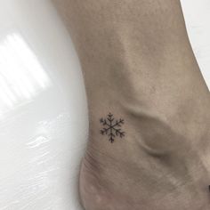 a small snowflake tattoo on the ankle