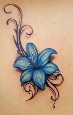 a blue flower on the back of a woman's upper back shoulder and arm