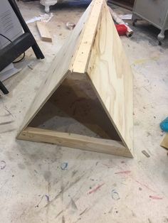 a wooden triangle sitting on top of a hard wood floor