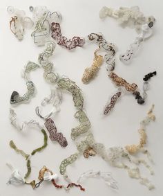 many different types of necklaces on a white surface