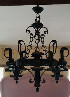 a chandelier hanging from the ceiling in a room with pink walls and beams