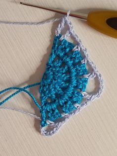 a crochet square is shown next to a pair of scissors