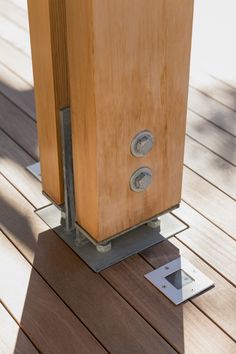 a wooden box sitting on top of a wooden floor next to a square metal object