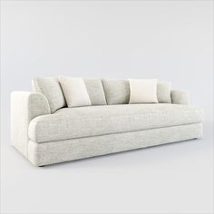 a white couch with four pillows on it's back and one arm facing the camera