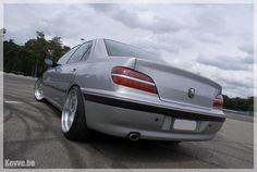 the rear end of a silver car parked in a parking lot