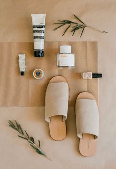 an assortment of items laid out on top of a mat next to a pair of sandals