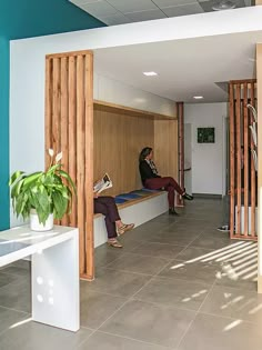 a woman sitting on a bench in a room with blue walls and wood slats