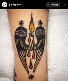 a tattoo on the leg of a person with two eyes and an arrow in the center