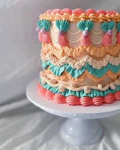 there is a multi layer cake on a white plate and it looks like it has been decorated with icing