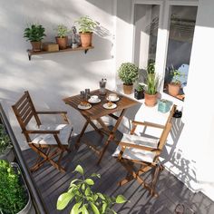 an outdoor table and chairs with potted plants