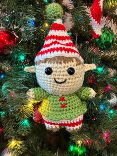 a crocheted elf ornament hanging from a christmas tree