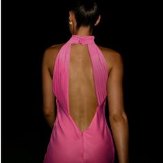 the back of a woman's body in a pink dress with an open neck