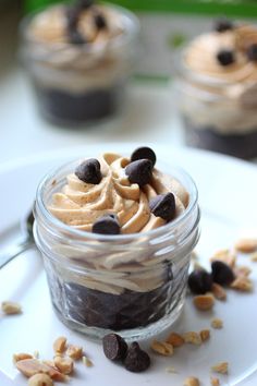 two desserts with chocolate chips and peanut butter in a jar on a white plate