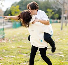 a man and woman are hugging in the park