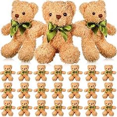 a group of teddy bears sitting next to each other with green bows on their heads