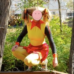 a woman dressed as a pig poses for a photo in front of some trees and bushes