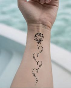 a woman's wrist tattoo with three hearts and roses on it, in black ink