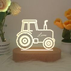 a light up tractor with the word love on it next to some flowers and vases