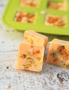 three pieces of soap sitting on top of a table next to a green tray filled with food