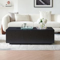 a living room with a white couch and black coffee table