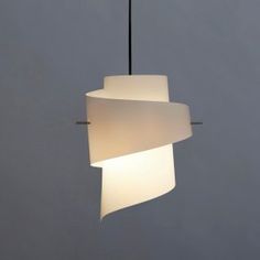 a white light hanging from a ceiling in front of a gray wall and grey sky