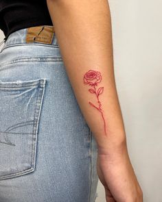 a woman's arm with a rose tattoo on the left side of her arm