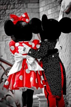 two mickey and minnie mouse dolls standing next to each other