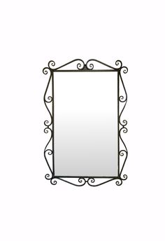 a mirror that is on the wall with an iron frame and scrollwork around it