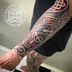 a man's arm with an intricate tattoo design on the forearm and leg,