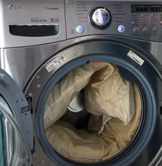 a washing machine with the door open and some cloths in it's front