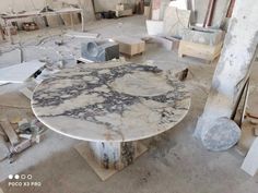 a marble table sitting inside of a room filled with wood and other items on the floor