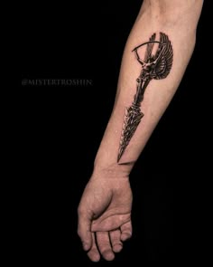 a person with a tattoo on their arm holding a knife in one hand and an arrow in the other