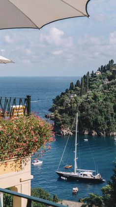 a sailboat is in the water next to an island with flowers growing on it