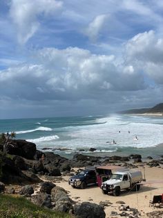 several vehicles parked on the beach near the ocean