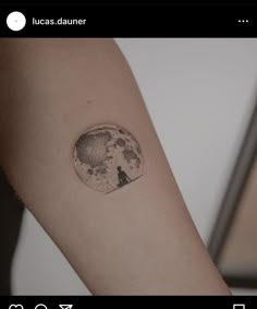 a person's arm with a tattoo on it that has a wolf in the moon