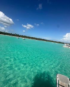 the water is crystal blue and clear with boats in it