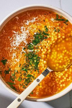 a white bowl filled with soup and topped with parmesan cheese