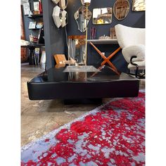 a black coffee table with red and white rug on it in a room filled with mirrors